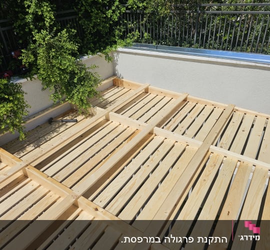 עבודת עץ בגינה עם לוחות עץ ומסגרת